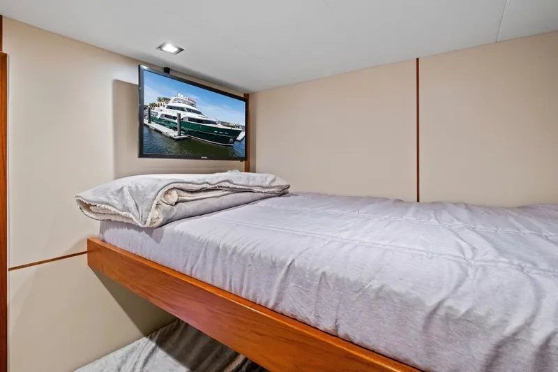 Slide: The Image of Cozy cabin interior of 2024 Marlow 90 V yacht with bed and wall-mounted TV. - 95