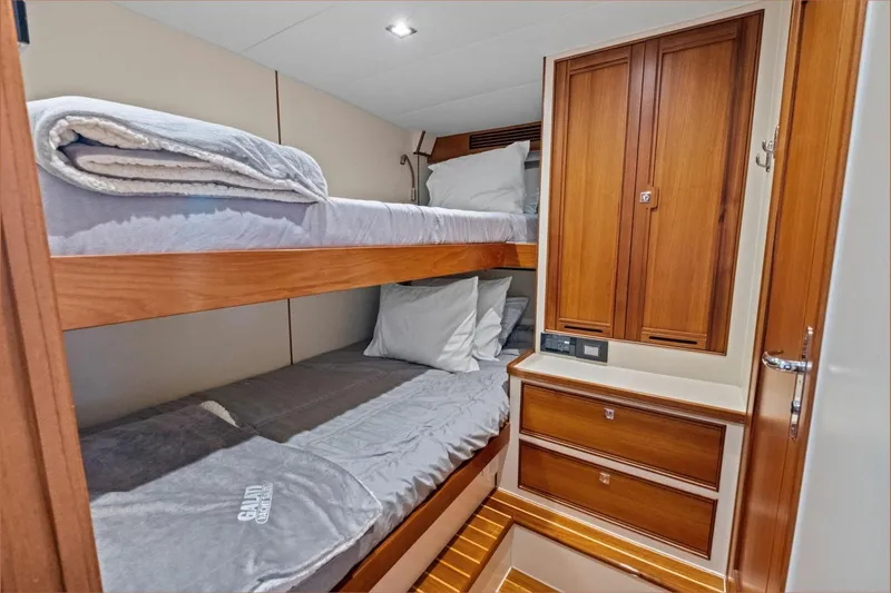 Slide: The Image of Luxurious 2024 Marlow 90 V yacht cabin with wooden bunk beds and storage. - 96