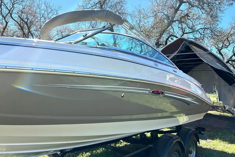 Slide: The Image of 2009 Sea Ray 210 boat on trailer, parked outdoors under clear blue sky. - 15