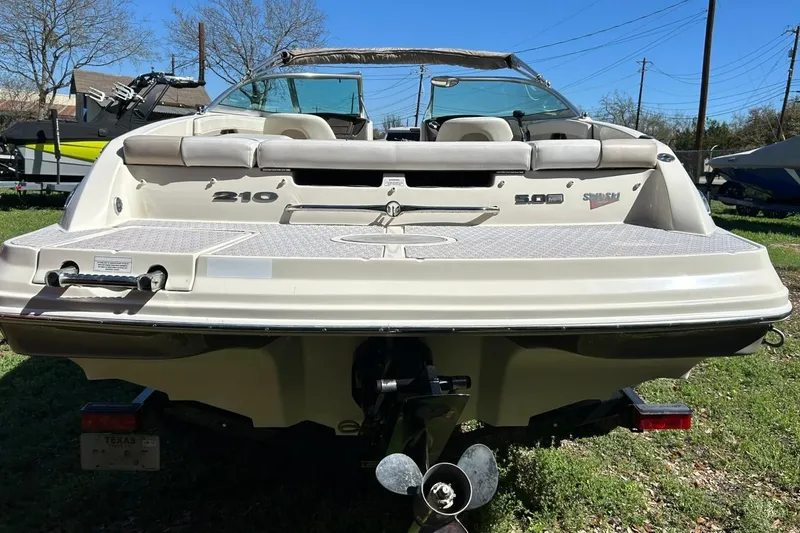 Slide: The Image of 2009 Sea Ray 210 boat rear view with seating and outboard motor. - 16