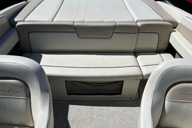 Slide: The Image of 2009 Sea Ray 210 boat interior with beige leather seating and storage compartment. - 18