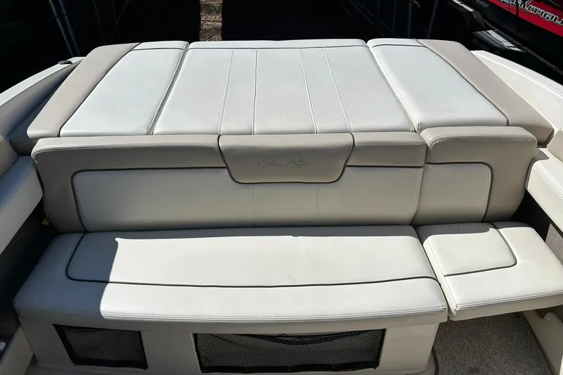 Slide: The Image of 2009 Sea Ray 210 boat with beige cushioned seating and storage compartments. - 19