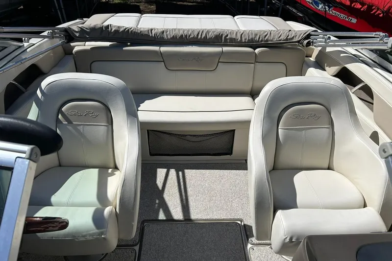Slide: The Image of 2009 Sea Ray 210 boat interior with beige leather seats and carpeted flooring. - 25