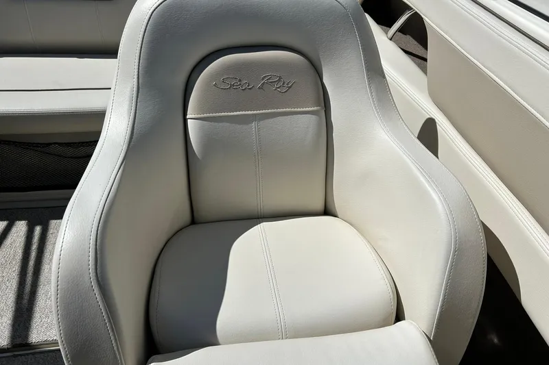 Slide: The Image of 2009 Sea Ray 210 boat seat with embroidered logo, featuring light gray upholstery. - 26