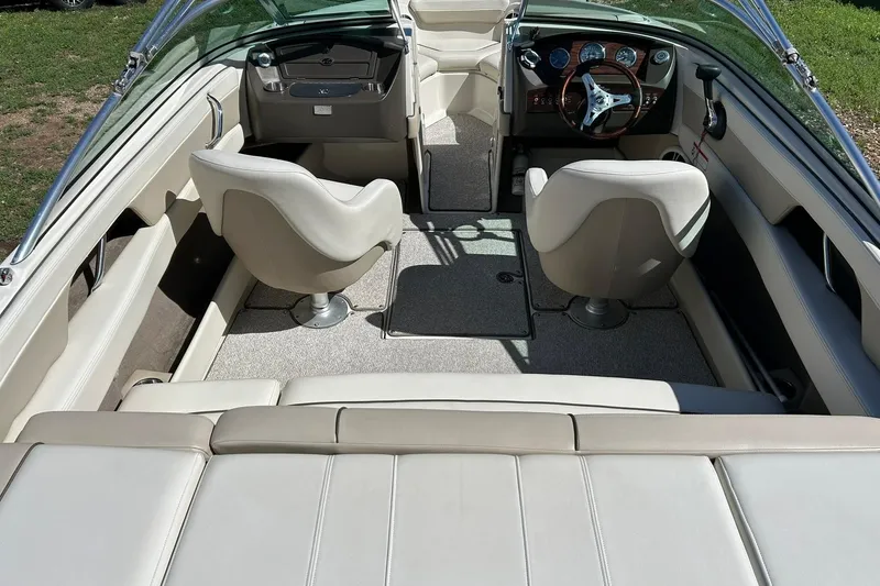 Slide: The Image of Interior of a 2009 Sea Ray 210 boat with beige seating and steering console. - 3