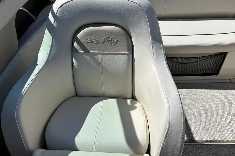 Slide: The Image of 2009 Sea Ray 210 boat seat with embroidered logo, featuring light gray upholstery. - 33