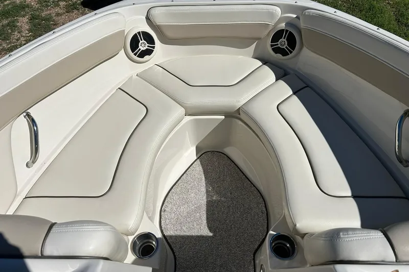 Slide: The Image of 2009 Sea Ray 210 boat interior with beige seating and built-in speakers. - 34