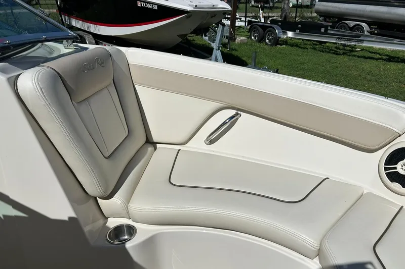 Slide: The Image of 2009 Sea Ray 210 boat interior with beige seating and cup holder. - 36