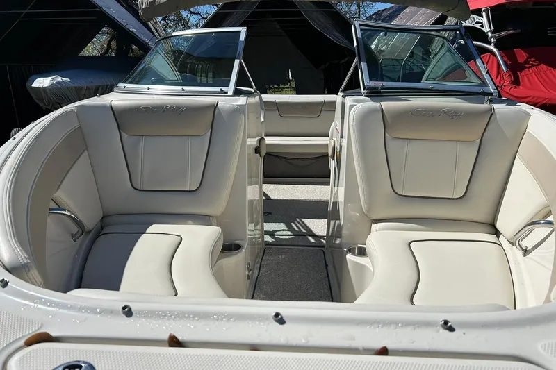 Slide: The Image of 2009 Sea Ray 210 boat interior with beige seating and open windshield. - 38
