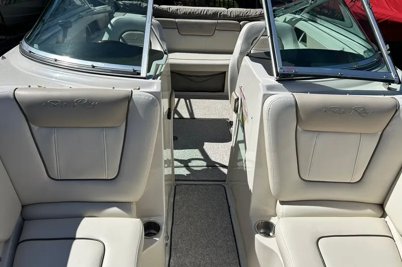 Slide: The Image of 2009 Sea Ray 210 boat interior with beige seating and open windshield. - 39