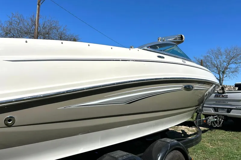 Slide: The Image of 2009 Sea Ray 210 boat on trailer, side view under clear blue sky. - 5