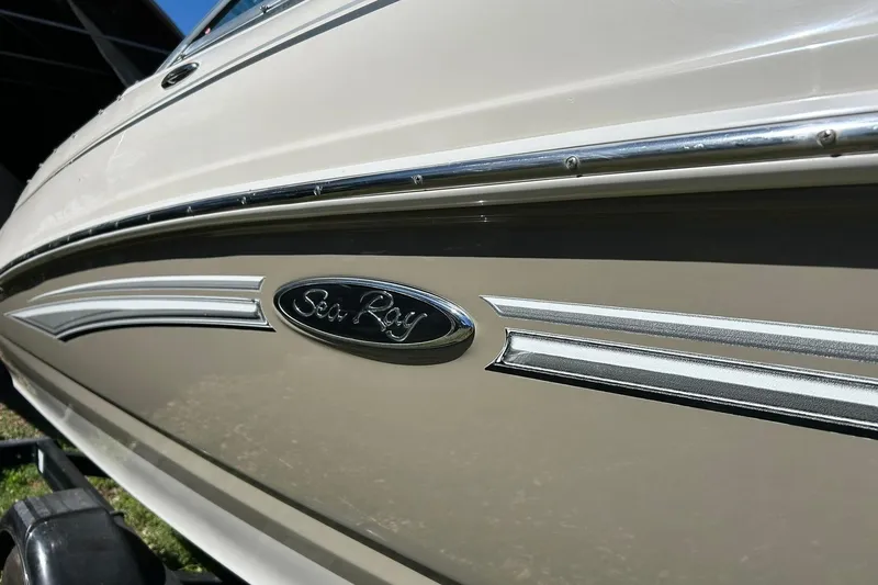 Slide: The Image of 2009 Sea Ray 210 boat side view with logo and chrome detailing. - 8