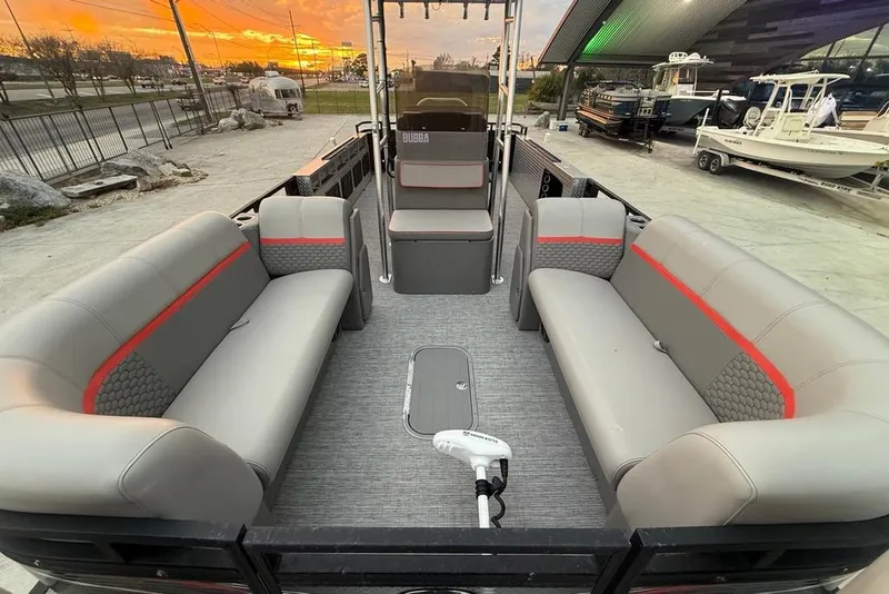 Slide: The Image of 2022 Apex Marine 8524 Pro Fish N Cruise pontoon boat interior with gray seating and red accents. - 10