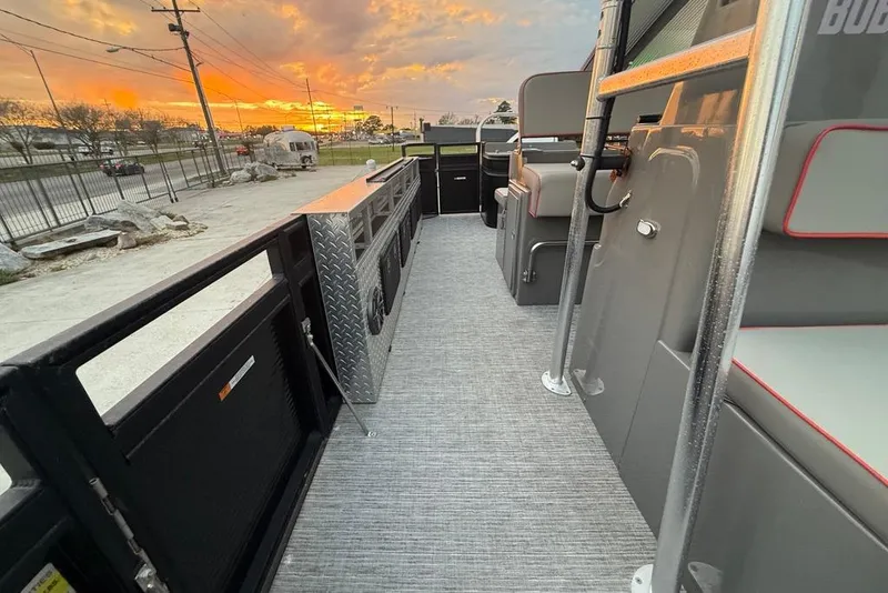 Slide: The Image of 2022 Apex Marine 8524 Pro Fish N Cruise boat interior at sunset, showcasing seating and storage. - 16