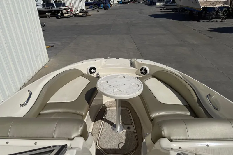Slide: The Image of 2007 Sea Ray 270 Sundeck boat interior with seating and table in a marina setting. - 19