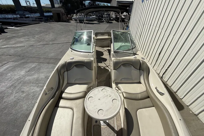 Slide: The Image of 2007 Sea Ray 270 Sundeck boat with spacious seating and table, docked outdoors. - 22