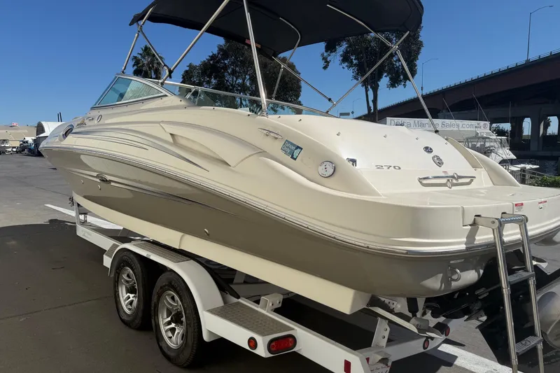 Slide: The Image of 2007 Sea Ray 270 Sundeck boat on trailer, parked outdoors under clear sky. - 4