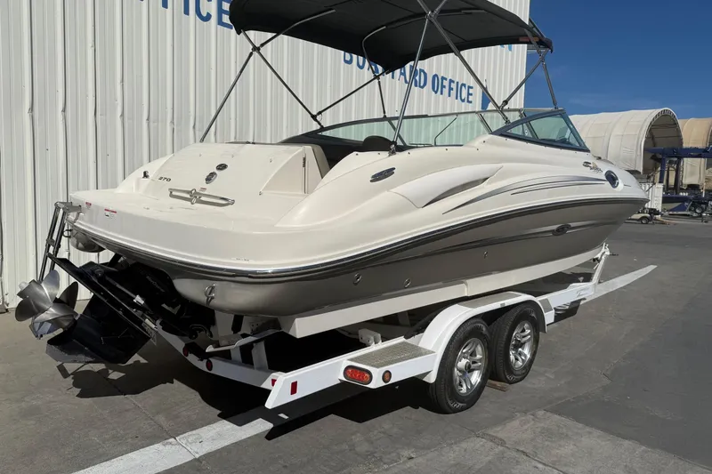 Slide: The Image of 2007 Sea Ray 270 Sundeck boat on trailer, parked near a building. - 6
