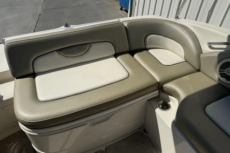Slide: The Image of 2007 Sea Ray 270 Sundeck boat seating with beige upholstery and cup holder. - 9