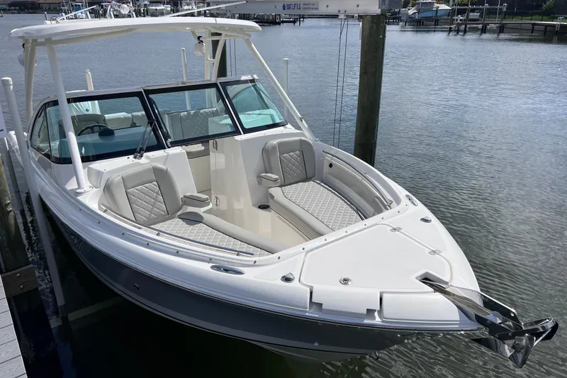 Slide: The Image of 2022 Pursuit DC 246 Dual Console boat docked in a marina. - 12