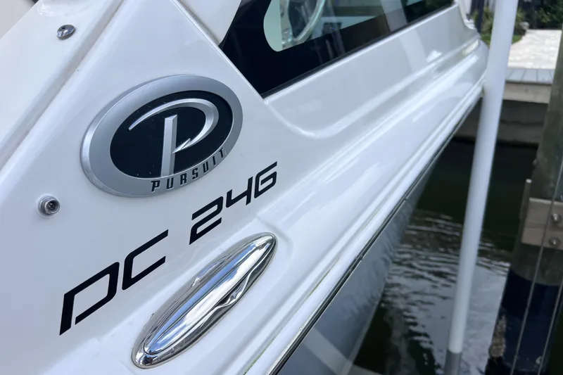 Slide: The Image of 2022 Pursuit DC 246 Dual Console boat side view with logo and model name. - 15