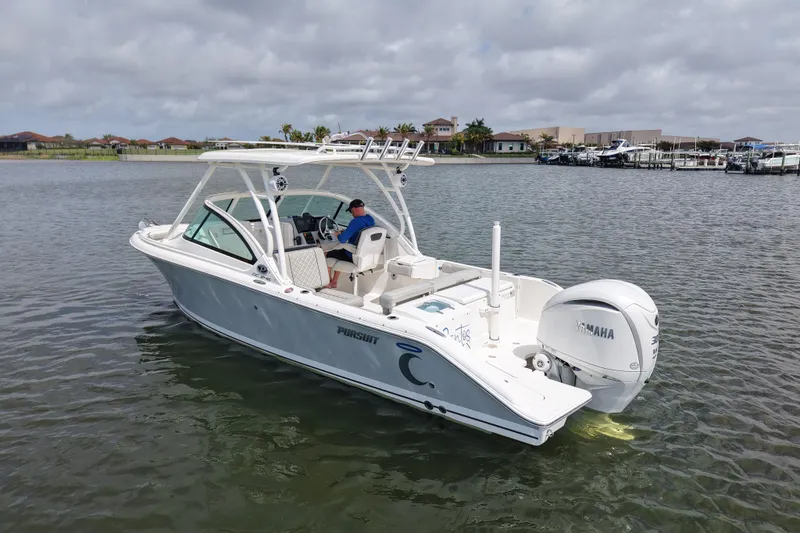 Slide: The Image of 2022 Pursuit DC 246 Dual Console boat on calm water, featuring a Yamaha engine. - 2