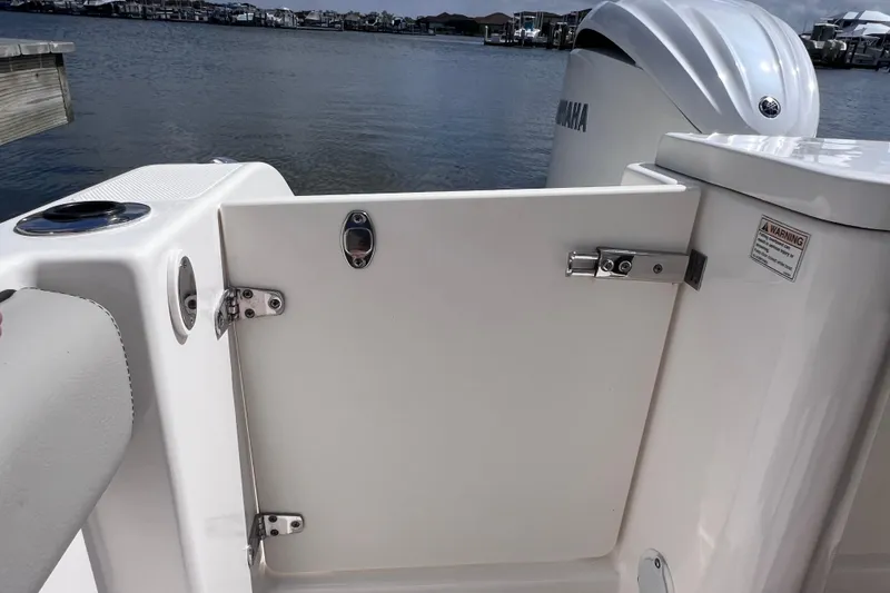 Slide: The Image of 2022 Pursuit DC 246 Dual Console boat with open transom door, dockside view. - 28