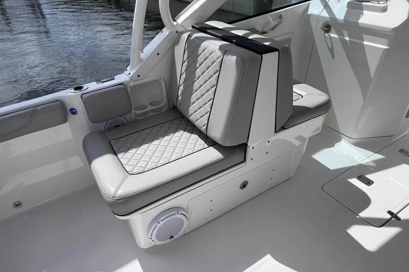 Slide: The Image of 2022 Pursuit DC 246 Dual Console boat interior with cushioned seating and storage. - 29