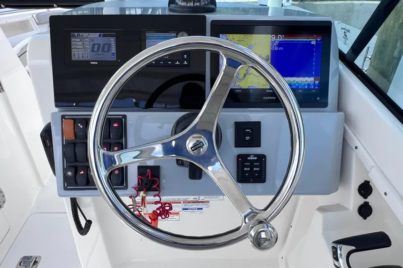 Slide: The Image of 2022 Pursuit DC 246 Dual Console helm with steering wheel and navigation displays. - 38