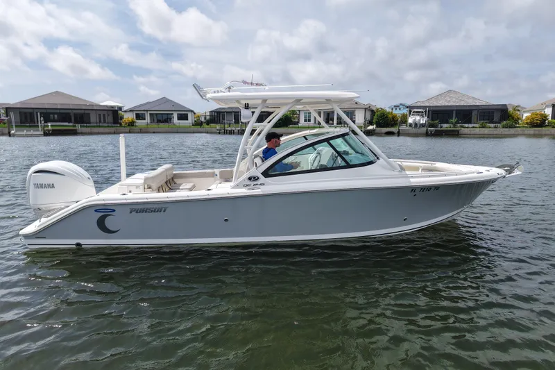 Slide: The Image of 2022 Pursuit DC 246 Dual Console boat on calm water, featuring Yamaha engine. - 4