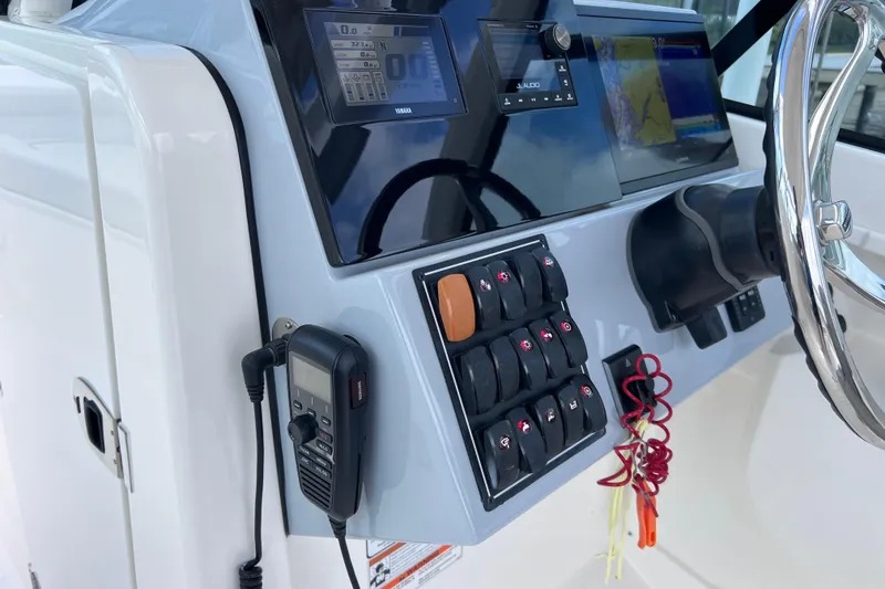 Slide: The Image of Control panel of 2022 Pursuit DC 246 Dual Console boat with steering wheel and electronic displays. - 45