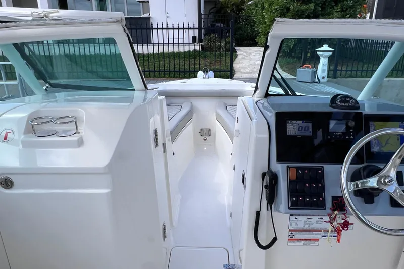 Slide: The Image of 2022 Pursuit DC 246 Dual Console boat interior with steering wheel and dashboard controls. - 50