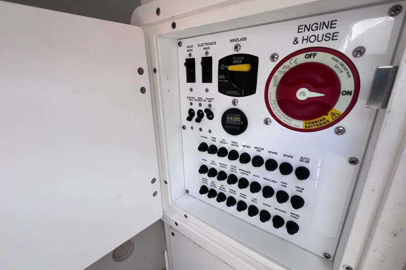Slide: The Image of Control panel of 2022 Pursuit DC 246 Dual Console boat, featuring switches and battery controls. - 52