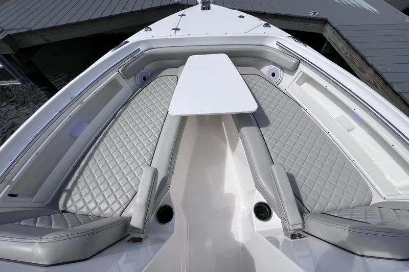 Slide: The Image of 2022 Pursuit DC 246 Dual Console boat with gray quilted seating and a central table. - 53