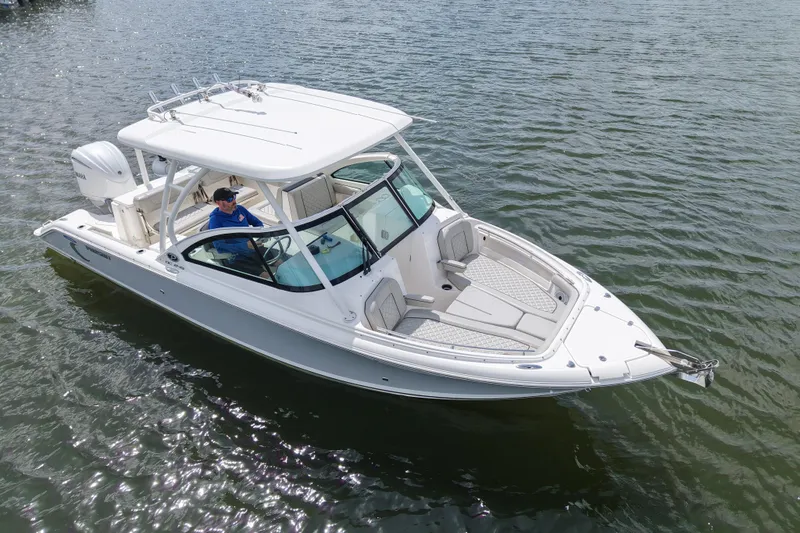 Slide: The Image of 2022 Pursuit DC 246 Dual Console boat on calm water, featuring sleek design and spacious seating. - 6