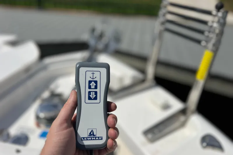 Slide: The Image of Hand holding Lewmar remote on 2022 Pursuit DC 246 Dual Console boat deck. - 61