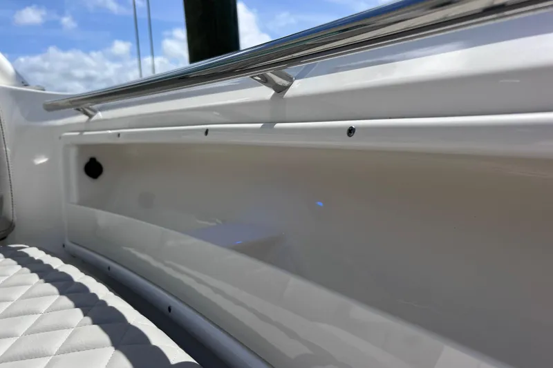 Slide: The Image of 2022 Pursuit DC 246 Dual Console interior detail with quilted seating and sleek railing design. - 62