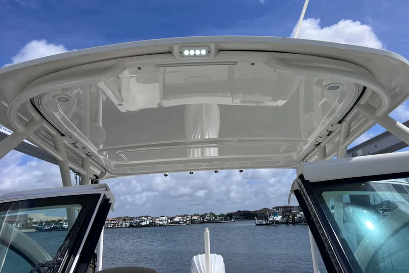 Slide: The Image of 2022 Pursuit DC 246 Dual Console boat with hardtop, docked by the water. - 63