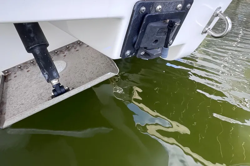 Slide: The Image of 2022 Pursuit DC 246 Dual Console boat trim tab and water reflection. - 68