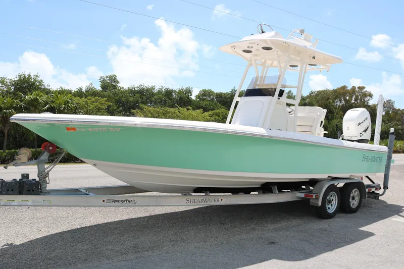 The Image of 2019 ShearWater 26 Carolina boat on trailer, mint green hull, clear sky background. - 1