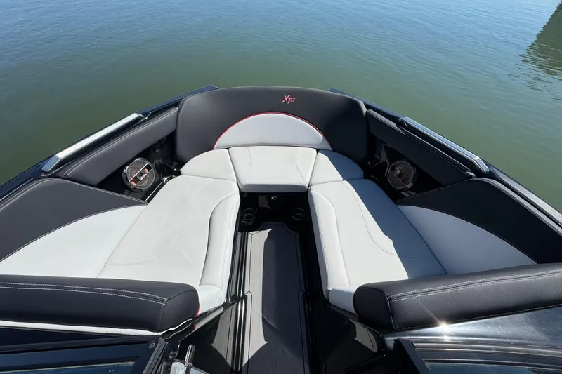 Slide: The Image of 2019 MasterCraft XT22 boat interior with sleek seating on calm water. - 11
