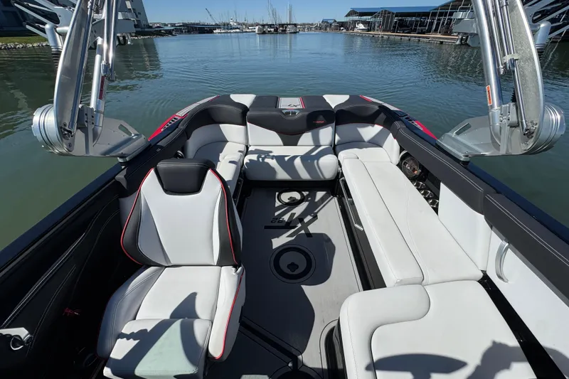 Slide: The Image of 2019 MasterCraft XT22 boat interior with sleek seating and modern design on calm water. - 14