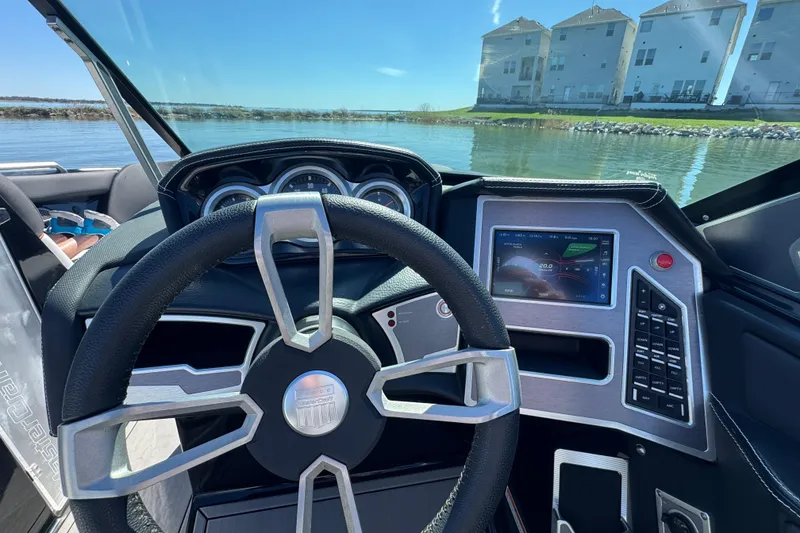 Slide: The Image of 2019 MasterCraft XT22 boat dashboard with steering wheel and digital display on a sunny day. - 15