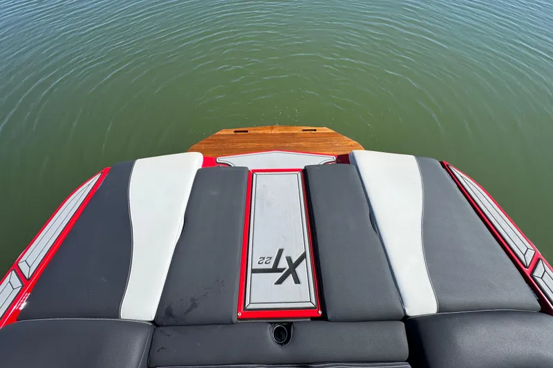 Slide: The Image of 2019 MasterCraft XT22 boat stern with cushioned seating and lake view. - 25