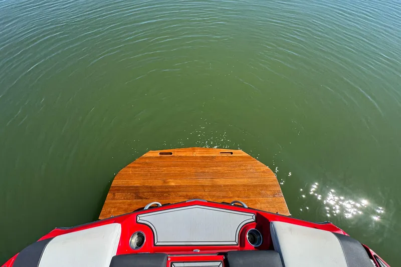 Slide: The Image of 2019 MasterCraft XT22 boat with wooden swim platform on calm water. - 26
