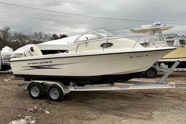 The Image of 2004 Hydra-Sports Lightning 212 WA boat on trailer, parked outdoors under cloudy skies. - 0