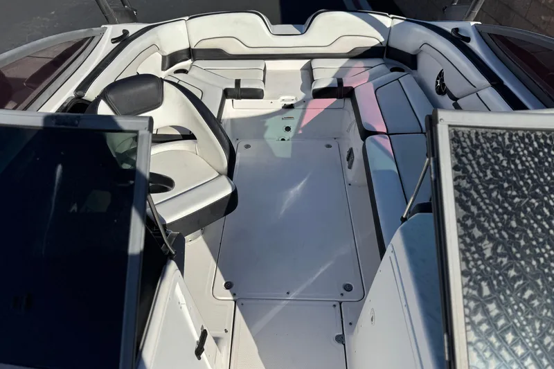 Slide: The Image of 2018 Yamaha Boats AR210 interior with white seating and spacious layout. - 16