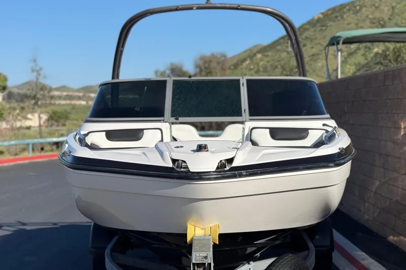 Slide: The Image of 2018 Yamaha Boats AR210 on trailer, parked outdoors with scenic background. - 2
