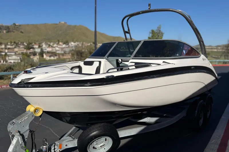 Slide: The Image of 2018 Yamaha Boats AR210 on trailer, parked outdoors with scenic background. - 3