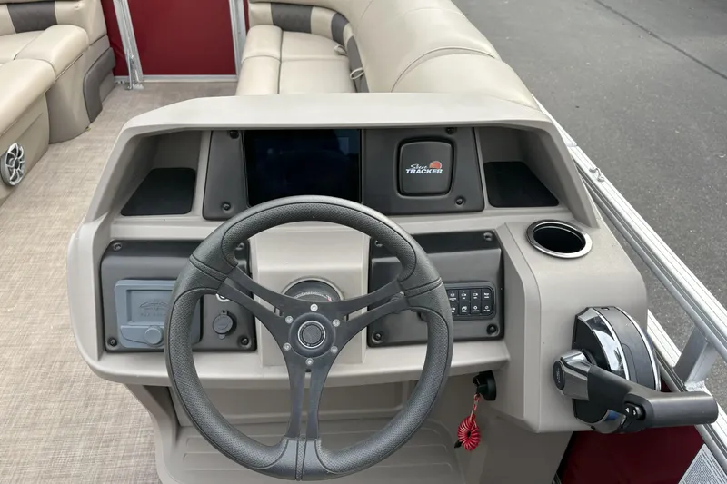 Slide: The Image of 2024 Sun Tracker Party Barge 20 DLX dashboard with steering wheel and controls. - 14